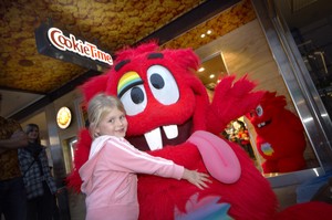 Olivia Davis-Richard gives her new friend the Cookie Muncher a hug after officially opening the store